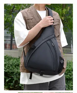 Outdoor shot of a black waterproof triangle chest bag with side mesh pocket and wide strap