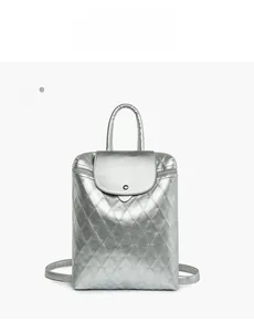 Detail view of silver quilted backpack featuring a metallic finish and magnetic flap closure