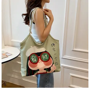 Detail of light green canvas tote bag featuring creative cartoon and Chinese characters