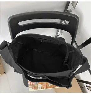 Interior view of black canvas tote bag featuring a spacious main compartment and zip pocket