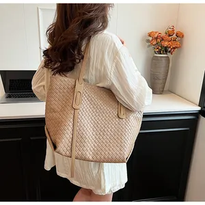 Dettaglio di una borsa tote intrecciata beige con texture Intrecciato e manici lunghi
