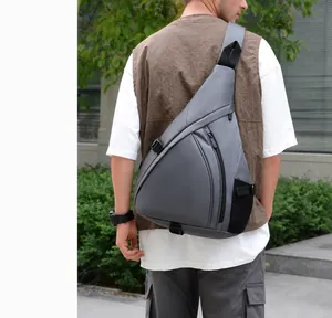 Outdoor shot of a grey triangle chest bag with black mesh side pocket for sports