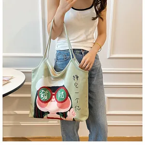 Detail of green canvas tote bag featuring a cute cartoon girl and Chinese slogan