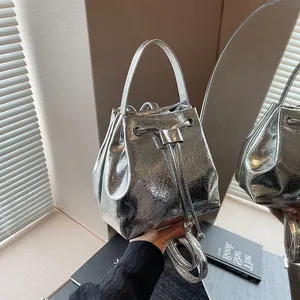 Detail of silver metallic bucket bag with cracked texture and drawstring closure