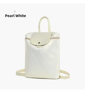 Detailed view of pearlescent white backpack with quilted patterns and silver buckle