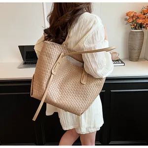Dettaglio della trama a intreccio quadrato su una grande borsa tote beige a tracolla