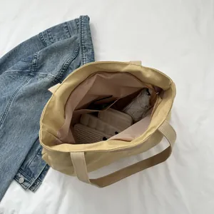 Top-down view of large canvas tote bag showing zipper pockets and spacious interior