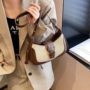 Detail of leather and straw woven shoulder bag with stylish metal buckle adjustment