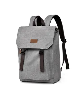Detail view of grey canvas backpack featuring durable flap cover and dark brown straps