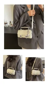 Vue détaillée du mini sac bandoulière crème avec texture crocodile et bijou sphérique