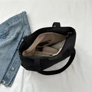 Top view of large black canvas tote bag interior with khaki lining and zipper pocket