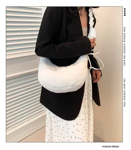 Vista dettagliata di una borsa a tracolla trapuntata bianca abbinata a un outfit moderno