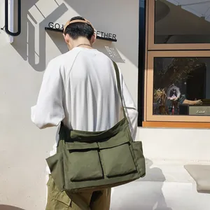 Army green large canvas messenger bag with double front pockets and wide shoulder strap