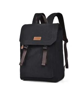 Detail of vintage black canvas backpack featuring brown adjustable buckle straps and flap