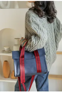 Detailed view of navy canvas tote bag with red and black striped shoulder straps