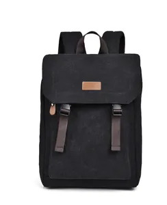Detail of black canvas backpack with brown leather accents and plastic buckle closures