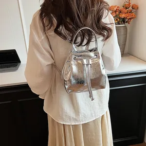 Close-up of metallic silver drawstring bucket bag showing crackle texture and metal details