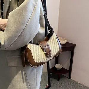 Detail of retro patchwork underarm bag showing brown leather texture and buckle