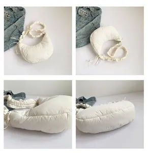 Viste dettagliate di una borsa hobo bianca a pieghe con trama e design a mezza luna