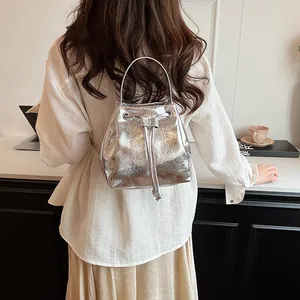 Detailed back view of a silver metallic drawstring bucket bag with a cracked leather texture