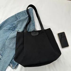 Detail of black canvas tote bag with FASHION patch and sturdy long shoulder handles