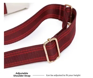 Detail of burgundy striped canvas shoulder strap with adjustable golden metal buckles