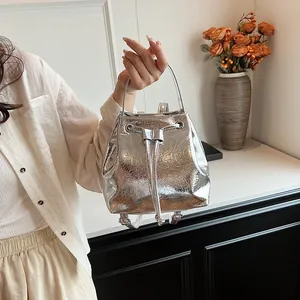 Detailed shot of silver metallic bucket bag with drawstring closure and top handle