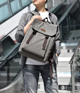 Deep gray canvas backpack featuring brown leather accents and side release buckle design