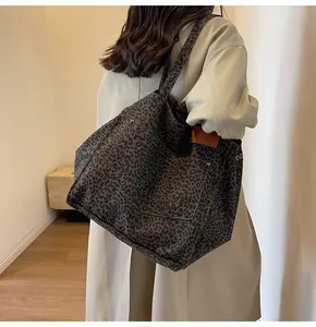 Detalle del bolso tote de lona con estampado de leopardo, bolsillo frontal y remaches