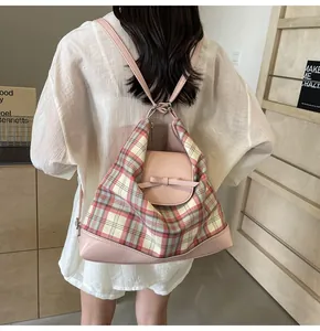 Detail eines rosa-weißen karierten Rucksacks mit Schleife, getragen von einem Modell