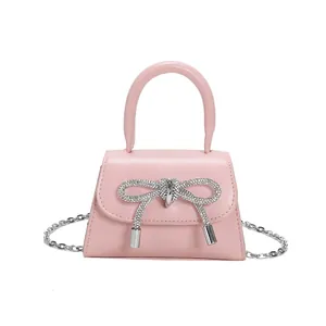 Pink mini crossbody bag with sparkling rhinestone bow and silver chain strap for girls