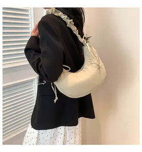 Dettaglio borsa hobo beige a mezzaluna con tracolla a pieghe e accenti con coulisse
