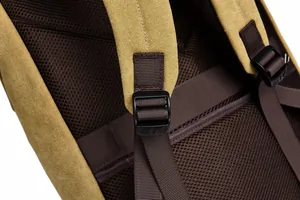 Detail of reinforced padded shoulder straps and breathable mesh back on the khaki canvas backpack