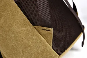 Detail of khaki canvas backpack with breathable brown mesh back and reinforced stitching