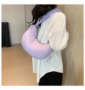 Dettaglio della tracolla a pieghe lilla e della trama in nylon della borsa a mezzaluna