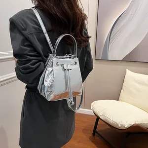 Detail of silver metallic bucket bag showing drawstring closure and shiny leather texture
