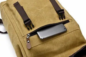 Detail of canvas backpack front pocket holding a tablet with secure buckle closure
