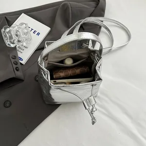 Silver metallic bucket bag with drawstring closure and versatile shoulder strap