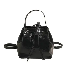 Glossy black patent leather backpack with drawstring closure and silver hardware