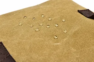 Detailed close-up showing the waterproof canvas texture with water droplets on the backpack