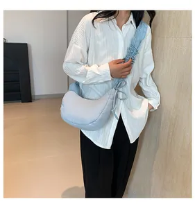 Dettaglio borsa a nuvola celeste con manico arricciato alla moda per look quotidiano
