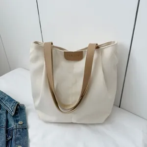 Close-up detail of the FASHION leather tag and textured canvas on the large tote bag
