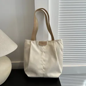 Detailed close-up of a canvas tote bag featuring a brown leather label with FASHION text