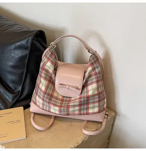 Detailansicht eines rosa karierten Rucksacks mit Lederbesatz und Schleifendetail