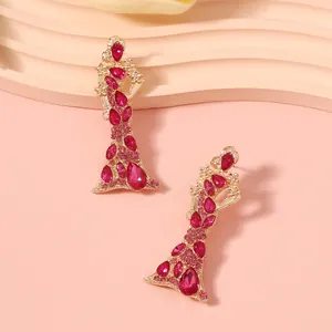 Dettaglio degli orecchini di lusso dorati con cristalli rosa vibranti per donne