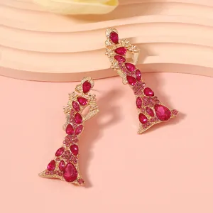 Macro di orecchini in lega dorata con cristalli magenta a forma di silhouette femminile