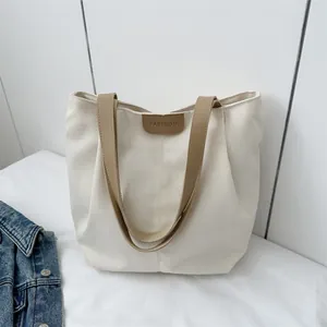Large white canvas tote bag with brown straps and fashion patch for daily commuting