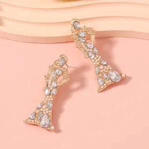 Dettaglio di orecchini d'oro di lusso con cristalli colorati e perle dal design silhouette