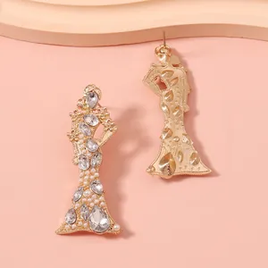 Dettaglio di orecchini a silhouette di donna in oro con cristalli e perle di lusso