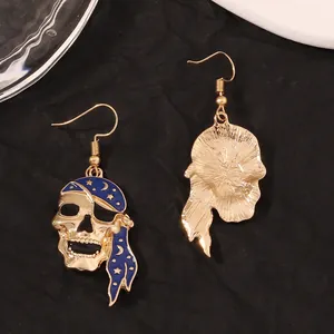 Detail of pirate skull earrings with navy blue enamel moon and star patterns